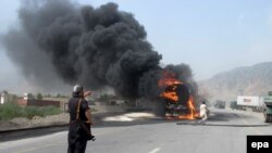 A Pakistani security official looks on as a truck said to be carrying NATO oil is engulfed in flames following an attack near the Afghan border in Jamrud on August 21, 2014.