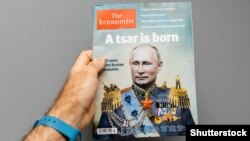 Мужчина держит журнал Economist с изображением на обложке президента России Владимира Путина с заголовком «Царь родился». Франция, Страсбург, 28 октября 2017 года.