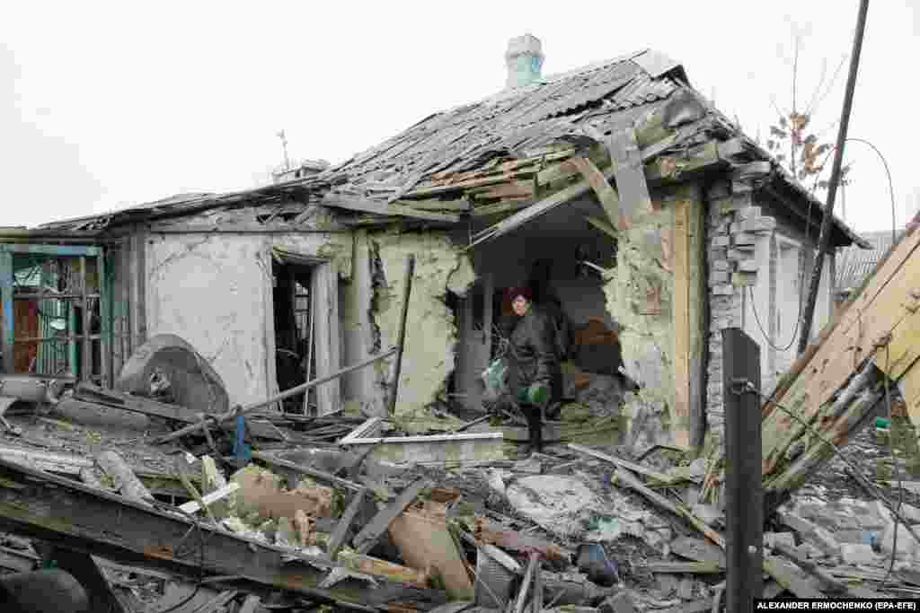 A woman inspects her damaged house after it was hit by shelling in the village of Yasinovataya, controlled by pro-Russia rebels, in the Donetsk region of eastern Ukraine. (epa-EFE/Aleksandr Ermochenko)