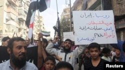 Residents carrying Free Syria Army flags chant slogans as they protest against Russian air strikes in Syria, in Aleppo on October 2.