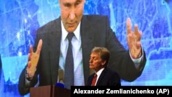 Пресс-секретарь президента России Дмитрий Песков на фоне выступления Владимира Путина