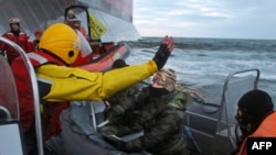 In this Greenpeace handout photo, a Russian Coast Guard troop holds a knife as activists try to climb Gazprom’s 'Prirazlomnaya' Arctic oil platform in the Pechora Sea on September 18.
