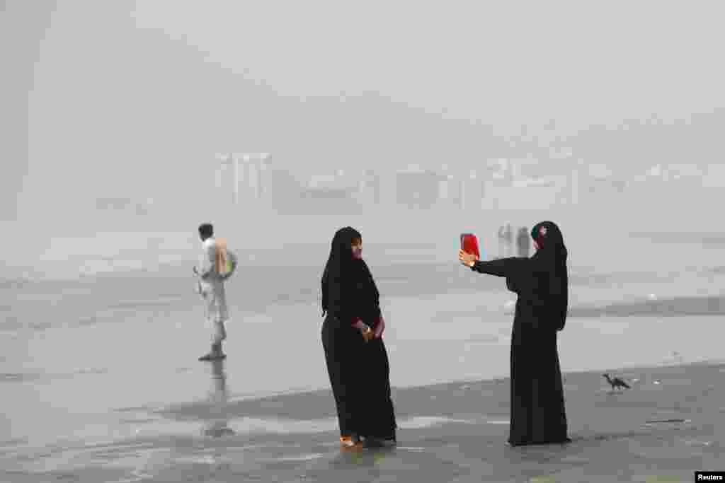 Дзяўчына фатаграфуе пляншэтам на пляжы ў Карачы, Пакістан, 28 кастрычніка. (Akhtar Soomro, Reuters)