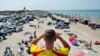 A lifeguard overlooks crowds at the beach on a hot summer day, at Blokhus