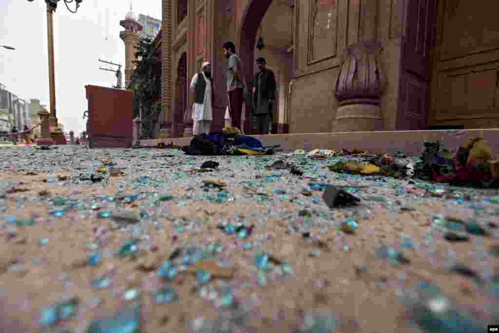 Copa të thyera xhami të një xhamie, të shpërndara në rrugë, pas shpërthimit vdekjeprurës me bombë që në shënjestër kishte një autobus në qytetin pakistanez të Peshavarit, më 16 mars.