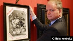 Eika Schmidt, directorul complexului muzeal Uffizi de la Florența, prezentînd fotografia tabloului furat de naziști 
