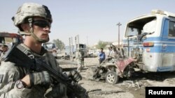 A U.S. soldier stands at the site of a bomb attack in Kirkuk on August 25. Continuing violence means the remaining 50,000 troops will still have much to do.