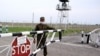 A border guard closes a barrier at the Korgas crossing, the largest on the 1,500-kilometer Kazakh-Chinese border.