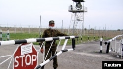 A Kazakh border guard closes a barrier at the Korgas crossing point, the largest on the 1,500-kilometer-long Kazakh-Chinese border.