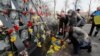 People place flowers at the memorial dedicated to people who died in the 2014 clashes with security forces on Kyiv's Independence Square on February 18, 2020.