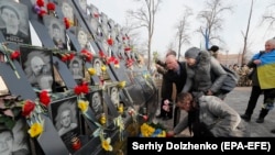 Njerëzit vendosin lule në memorialin kushtuar njerëzve që vdiqën në përleshjet e vitit 2014 me forcat e sigurisë në Kiev. Shkurt, 2020.