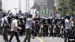 Basij militia members on motorcycles face off against protesters in Tehran in July 2009.