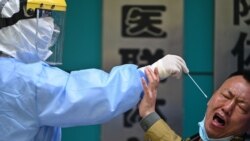 Чоловік емоційно реагує на те, як медичний працівник бере зразок для тесту на коронавірус в Ухані, 16 квітня 2020 року