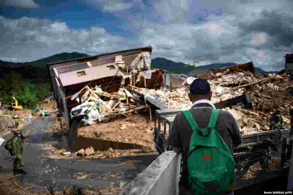 A man inspects a damaged house in a flood hit area of Hiroshima, Japan. (AFP/Martin Bureau)