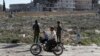A Syrian man and his kids ride a motorcycle in Manbij earlier this year.