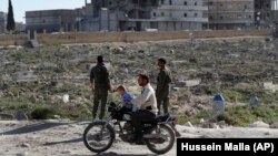 A Syrian man and his kids ride a motorcycle in Manbij earlier this year.