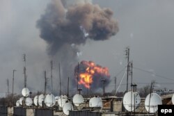 Smoke rises over a warehouse storing tank ammunition at a military base in Ukraine's Kharkiv region on march 23.
