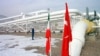 An Iranian worker stands in front of gas pipelines next to the flags of Turkey (R) and Iran. File photo