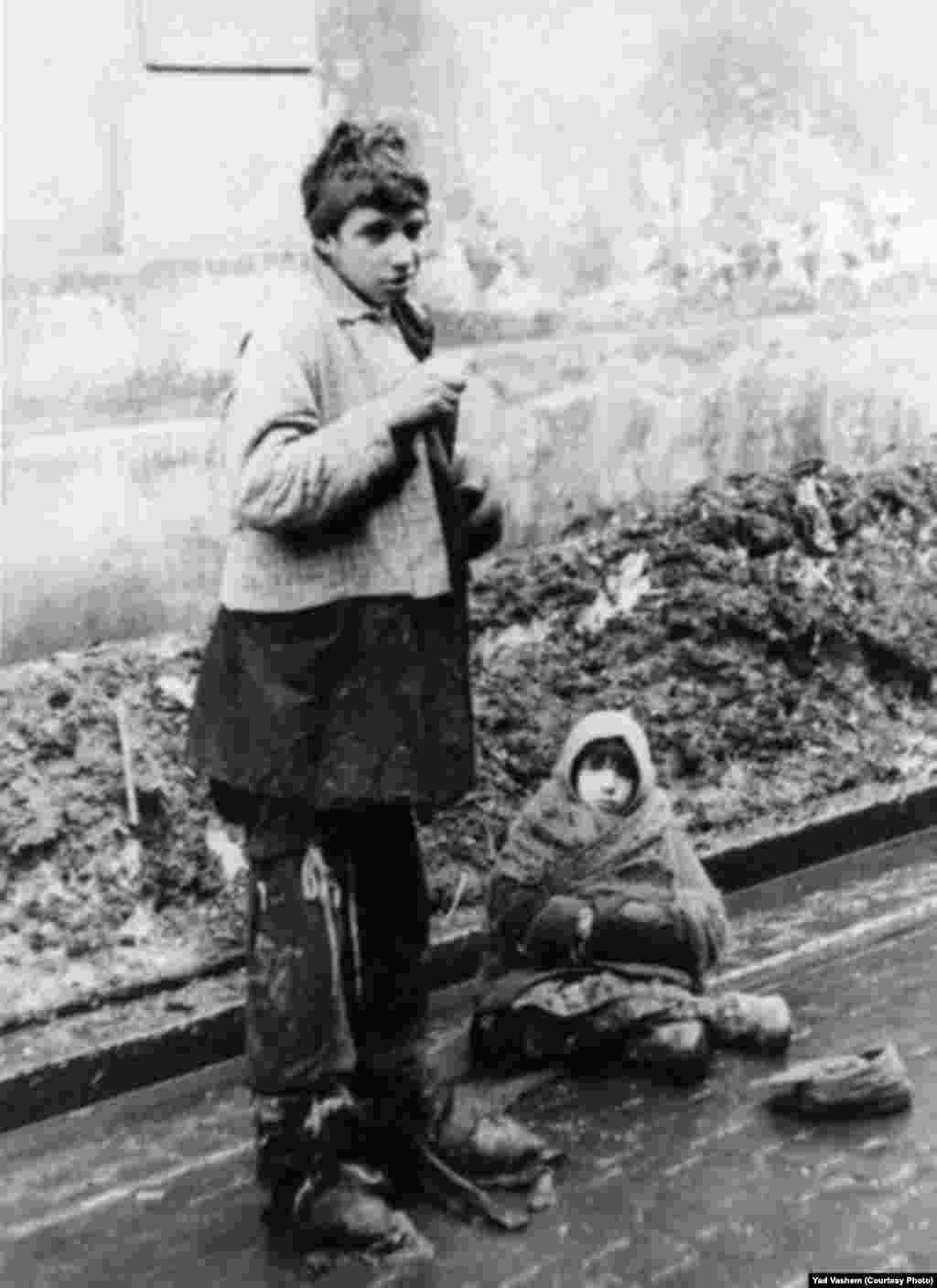 A young woman and a girl beg in the street.