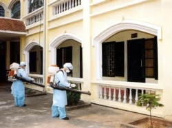 Ханой маңындағы аурухана аумағын дезинфекциялап жүрген медицина қызметкерлері. Вьетнам, 2003 жылдың сәуірі.