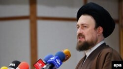 Hassan Khomeini, the grandson of late Iranian Supreme Leader Ayatollah Ruhollah Khomeini, speaks to reporters after registering his application to run for the Assembly of Experts on December 18.