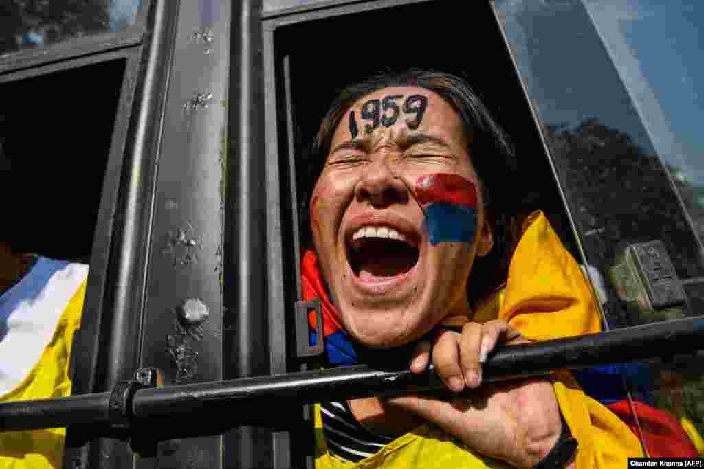 Қытай басшыларының Үндінстанға сапары қарсаңында қарсылық акциясын жасаған тибеттік қыз полиция көлігінен айғайлап тұр. 23 қазан 2018 жыл