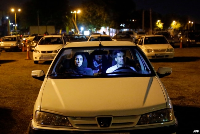 Iranians sit in their cars while taking part in a religious ceremony during the holy month of Ramadan in a parking in Tehran.