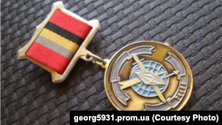 Медаль "На службе Отечеству" с эмблемой войсковой части 74455 ГУ ГШ МО РФ, упомянутой в обвинительном заключении Большого федерального жюри присяжных США