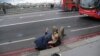 A woman assists an injured person after the incident on Westminster Bridge, next to the Houses of Parliament.&nbsp;