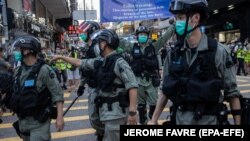 Полиция расчищает улицу во время молчаливого марша против принятия закона о национальной безопасности в Гонконге. Гонконг, 28 июня 2020 года.