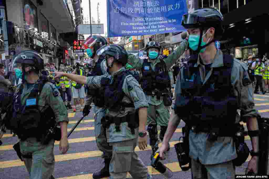 Police clear a street during a silent march against the national security law in Hong Kong, June 28, 2020. 
