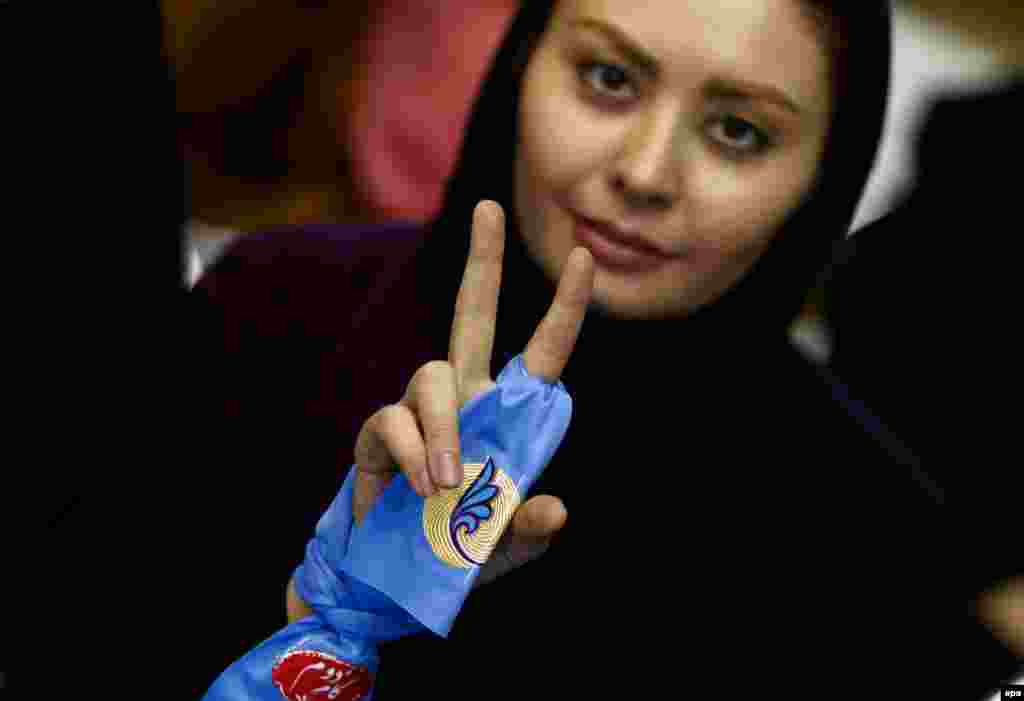 An Iranian supporter of pro-reform candidates flashes a victory sign in Tehran. Iranians go to the polls to vote for parliament and the Assembly of Experts on February 26. (epa/Abedin Taherkenareh)