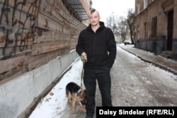 Ivan Sprynskyy, 29, head of a voluntary organization that delivers supplies to Ukrainian soldiers fighting in the country's east. He is standing with a 6-month-old German shepherd, one of two dogs donated by volunteers in the Czech Republic to be trained to detect explosives in the war zone.