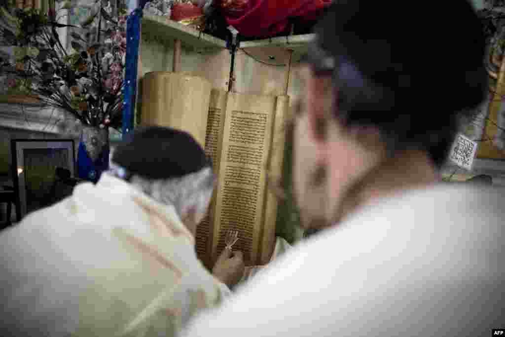 Iranian Jews read from the Torah scroll during morning prayers at the Yussef Abad Synagogue in Tehran.