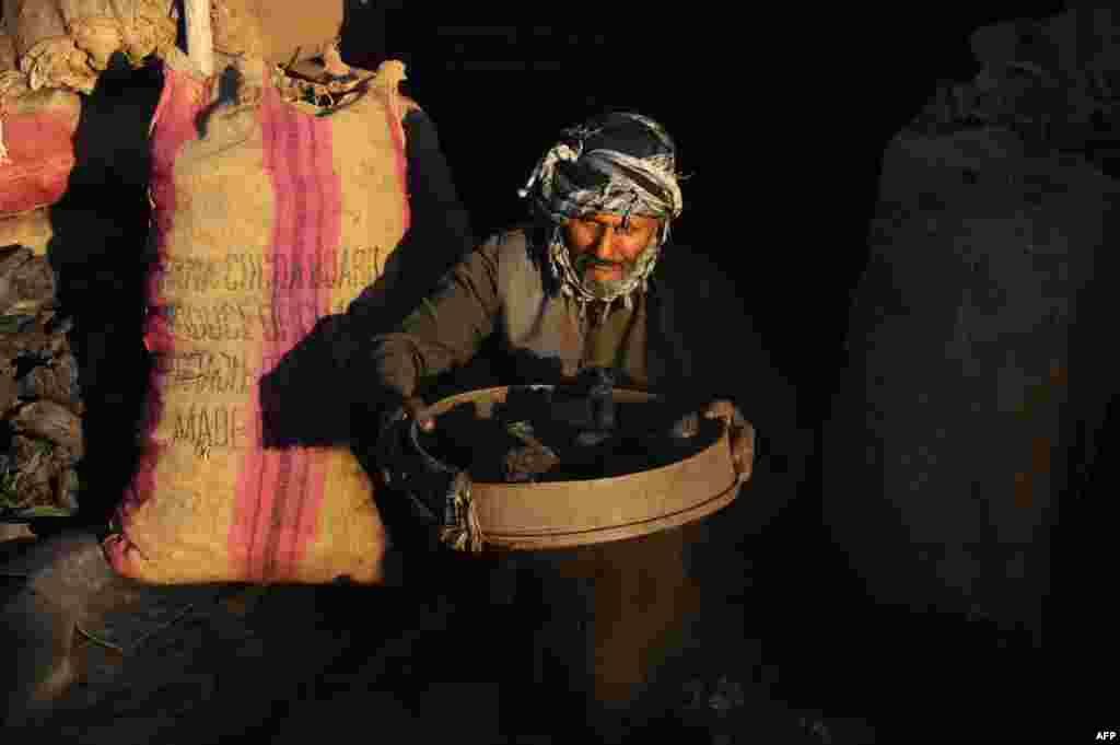 An Afghan man works at a coal shop in Herat's old city. (AFP/Aref Karimipotw)