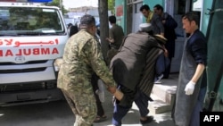 Afghan soldiers and voluntaries carry an injured man to a hospital following a suicide bomber attack with explosives packed in a vehicle in Ghazni Province on May 22.