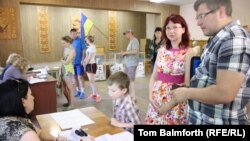 Masha and Anton Plitus pick up their ballot papers at a Bucha polling station on May 25.