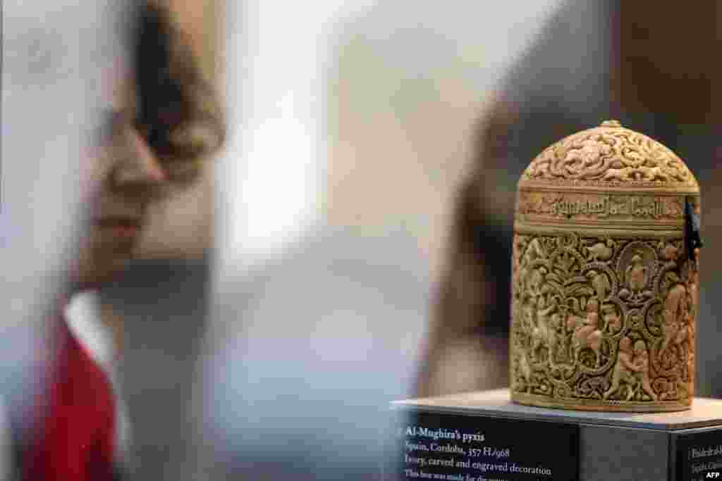A woman examines a box called "Al-Mughira's Pyxis" on a visit to the new Islamic Arts Department at the Louvre.
