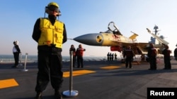 Chinese servicemen check a J-15 fighter jet on the Chinese aircraft carrier "Liaoning." (undated)