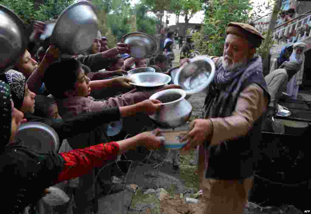 An Afghan man distributes food for the needy during the first day of the Islamic holy month of Ramadan in Ghazni Province on June 6. (AFP/Zakeria Hashimi)