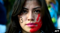 یکی از معترضان مکزیکی به جریان ناپدید شدن دانشجویان مکزیکی؛ شماره ۴۳ بر گونه راست او نماد ۴۳ دانشجوی ناپدید شده است