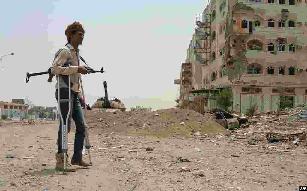 A fighter loyal to Yemen's exiled President Abedrabbo Mansour Hadi walks with crutches in Aden on July 30. (AFP)