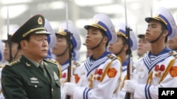 Chinese Defense Minister Liang Guanglie reviews an honor guard during a welcoming ceremony prior to the opening of the ASEAN meeting in Hanoi.