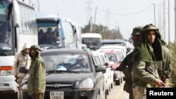 Libya -- Troops loyal to leader Muammar Qaddafi guard a checkpoint between the capital and the city of Zawiyah, 27Feb2011