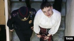 Nadia Savchenko is escorted as she leaves a court hearing in Moscow on April 17.