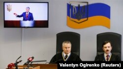Ukrainian President Petro Poroshenko is seen on an electronic screen as he testifies via a video link during the trial against former President Viktor Yanukovych in Kyiv on February 21.