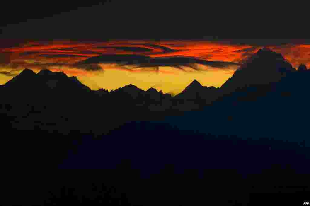 The French Alps are seen from Geneva under heavy clouds at sunrise. (AFP/Fabrice Coffrini)