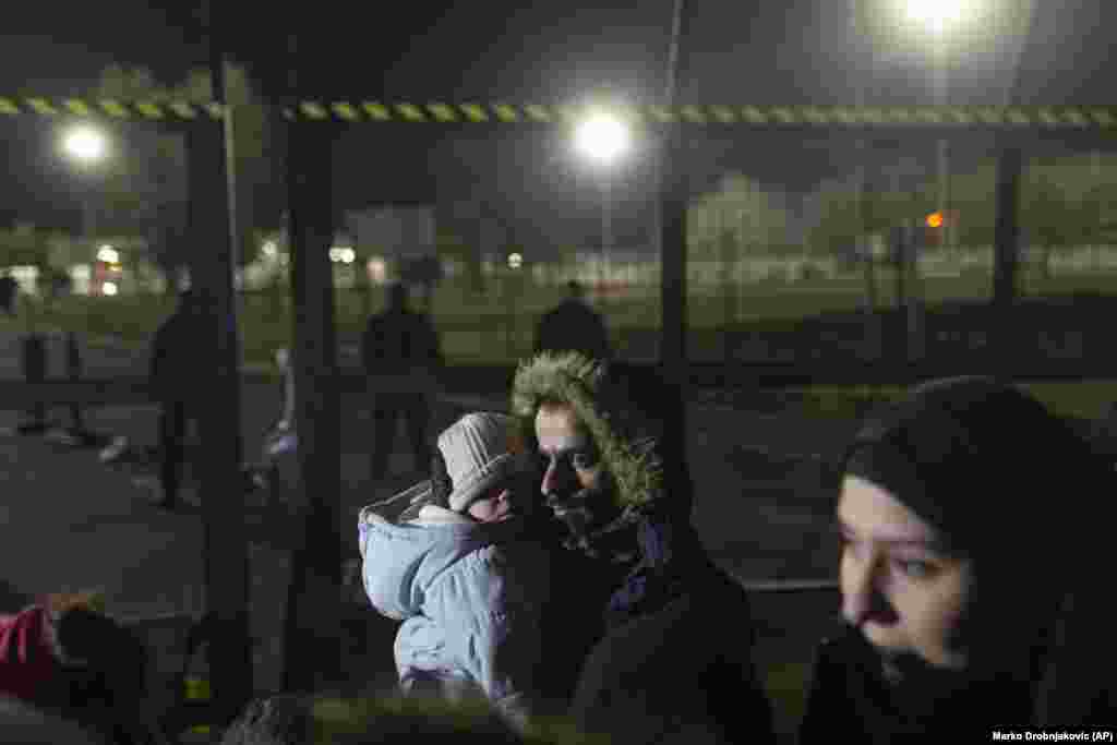 A man holds a child close to the border crossing. A Syrian woman, identified only as Amira, told Reuters the migrants wanted "a better life for our children."