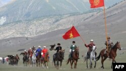 Конники несут флаги Кыргызстана на Всемирных играх кочевников. Семеновское ущелье.
