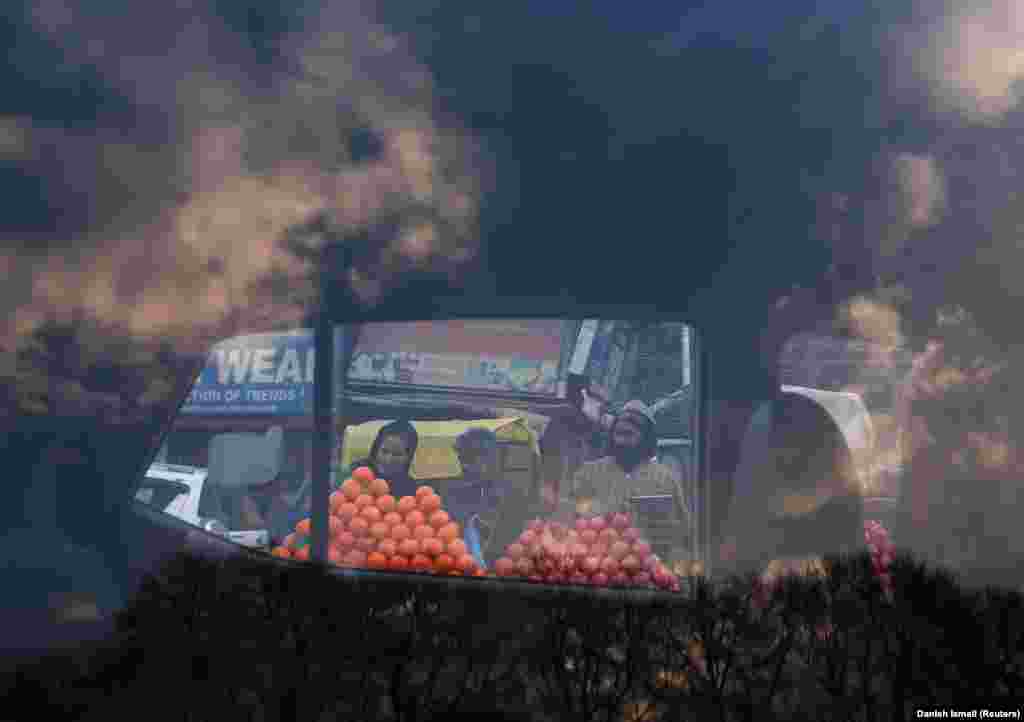 People buying fruit are seen through the window of a parked car at a market in Srinagar, India, on February 5. (Reuters/Danish Ismail)